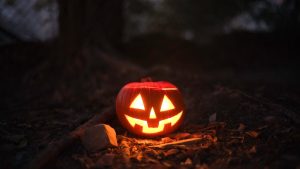 Glowing jack-o'-lantern in a spooky outdoor setting, perfect for Halloween themes.