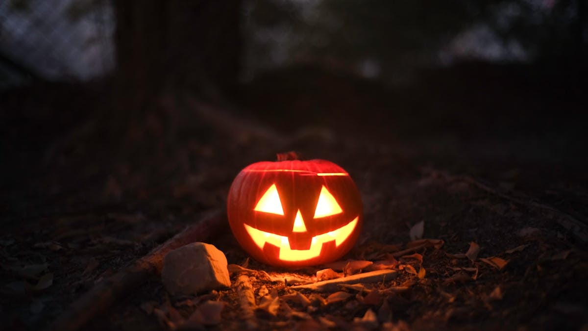 Glowing jack-o'-lantern in a spooky outdoor setting, perfect for Halloween themes.